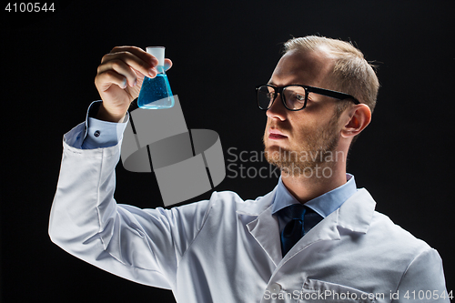 Image of young scientist holding test flask with chemical