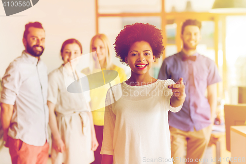 Image of woman pointing to you over creative office team