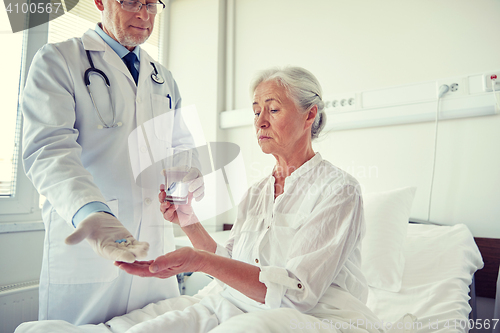 Image of doctor giving medicine to senior woman at hospital