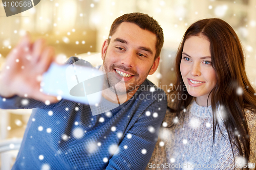 Image of couple taking smartphone selfie at cafe restaurant