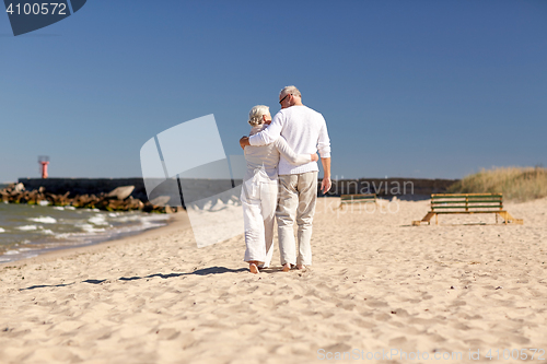 Image of happy senior couple hugging on summer beach