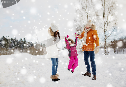 Image of happy family in winter clothes walking outdoors
