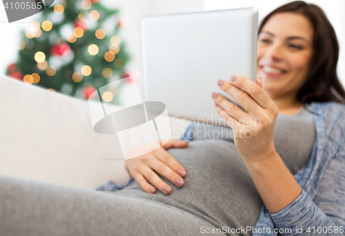 Image of close up of pregnant woman with tablet pc at home
