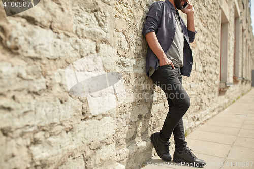 Image of close up of man calling on smartphone in city