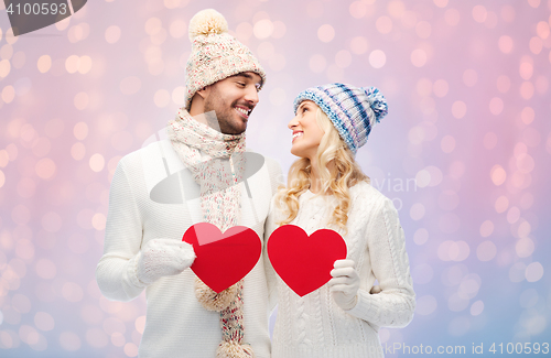 Image of smiling couple in winter clothes with red hearts