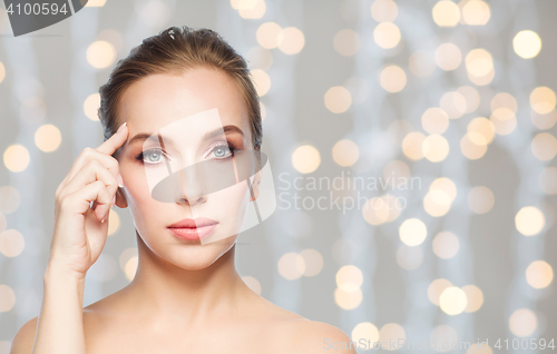 Image of beautiful woman pointing at her forehead