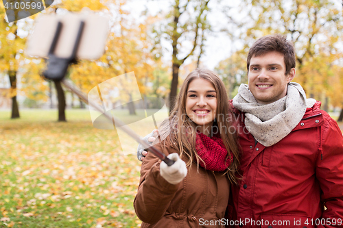 Image of couple taking selfie by smartphone in autumn park