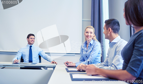 Image of group of smiling businesspeople meeting in office