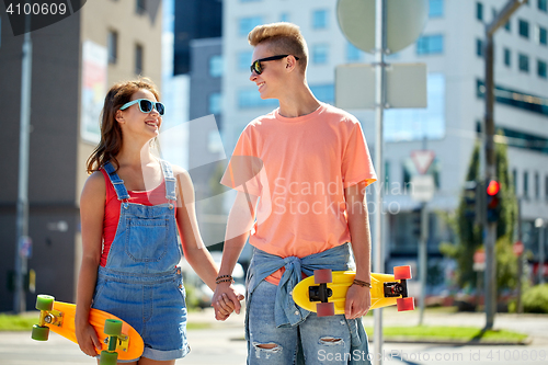 Image of teenage couple with skateboards on city street