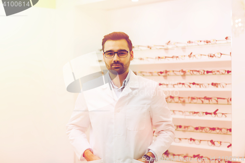 Image of man optician in glasses and coat at optics store