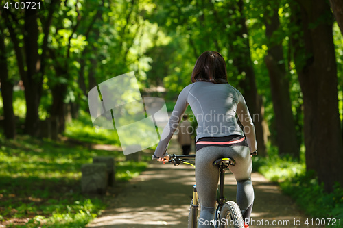 Image of cyclist woman riding a bicycle in park