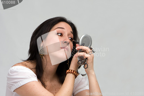 Image of Woman applying makeup