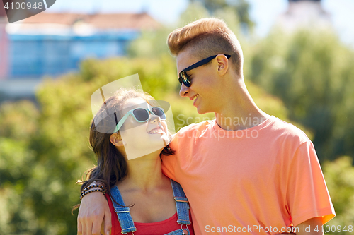 Image of happy teenage couple looking at each other in park