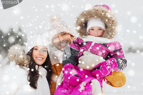 Image of happy family with child in winter clothes outdoors