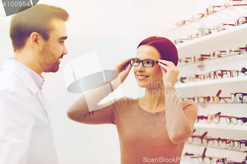 Image of woman choosing glasses at optics store