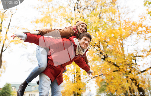 Image of happy young couple having fun in autumn park