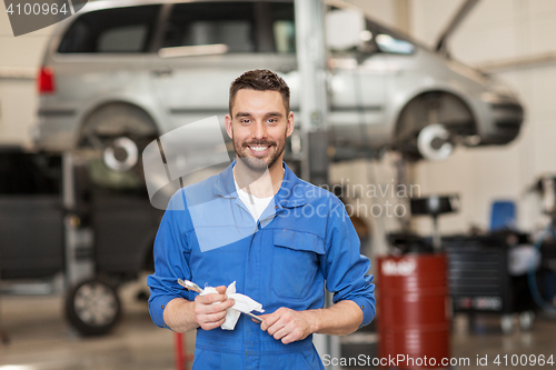 Image of auto mechanic or smith with wrench at car workshop