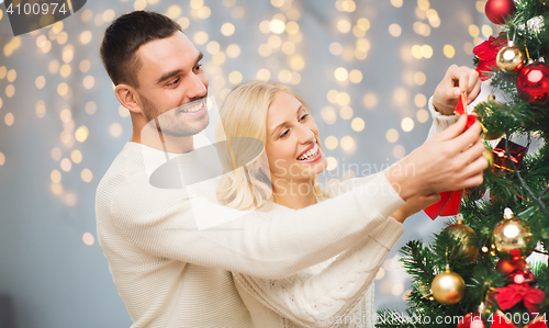 Image of happy couple decorating christmas tree