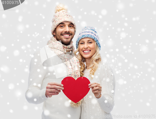 Image of smiling couple in winter clothes with red heart