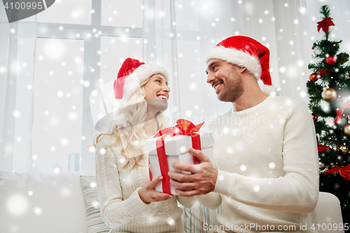 Image of happy couple at home with christmas gift box