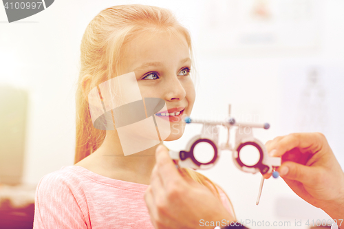 Image of optician with trial frame and girl at clinic