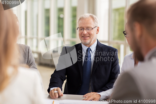 Image of smiling business people meeting in office