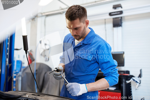 Image of mechanic man with wrench repairing car at workshop