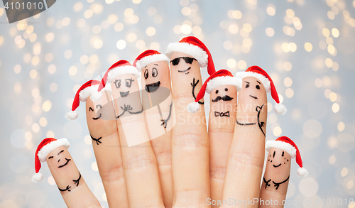 Image of fingers with smiley faces and santa hats