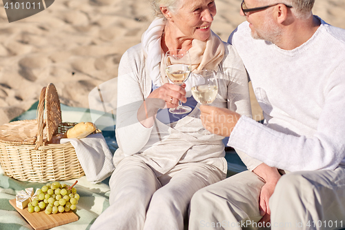 Image of happy senior couple having picnic on summer beach