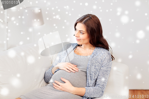 Image of happy pregnant woman lying on sofa at home