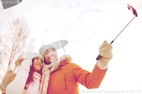 Image of happy couple taking selfie by smartphone in winter