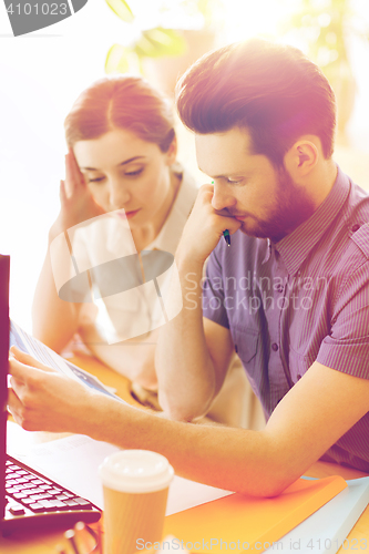 Image of creative team with reading paper in office