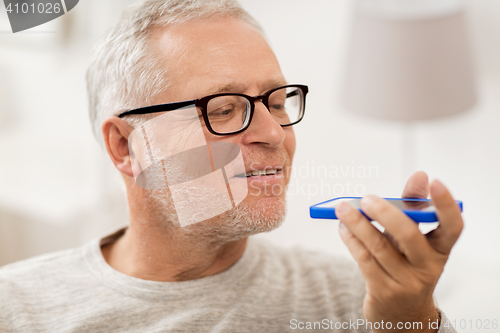 Image of old man using voice command recorder on smartphone