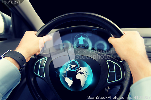 Image of close up of man driving car with globe on screen