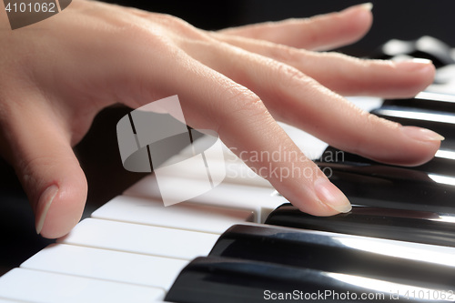 Image of Girl\'s hands on the keyboard of the piano