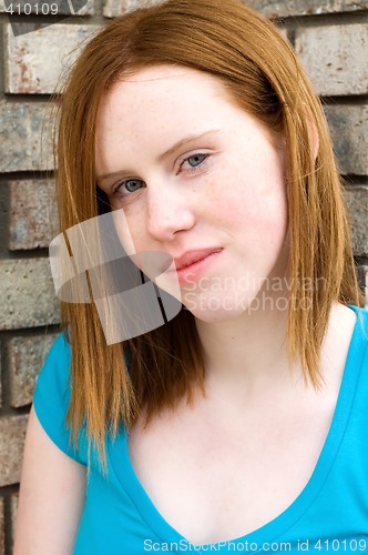 Image of Teen beside brick wall