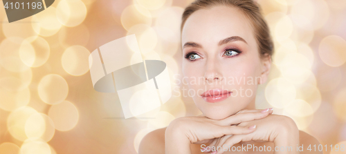 Image of beautiful young woman face and hands over lights