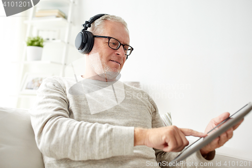 Image of senior man with tablet pc and headphones at home