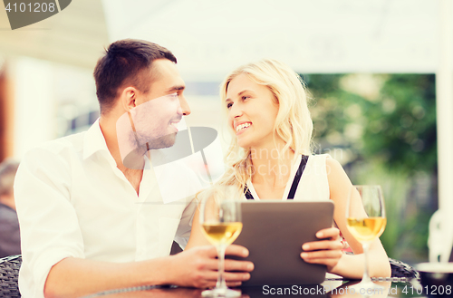 Image of happy couple with tablet pc at restaurant lounge