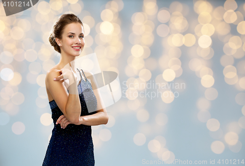 Image of smiling woman in evening dress over lights