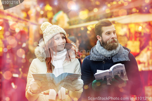 Image of happy couple with map and city guide in old town