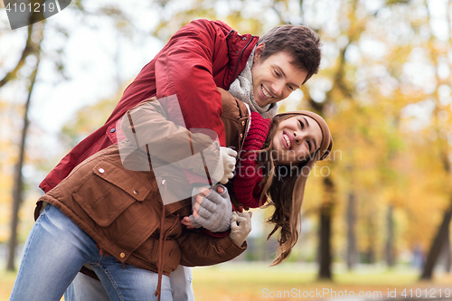 Image of happy young couple having fun in autumn park