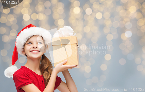 Image of smiling girl in santa hat with christmas gift box