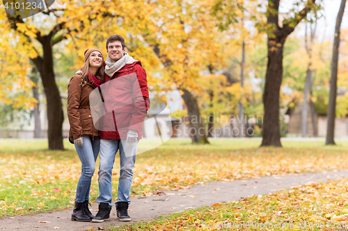Image of happy young couple walking in autumn park