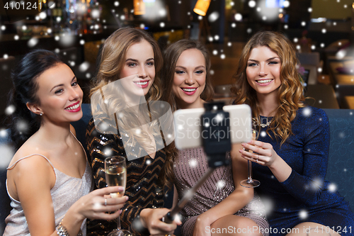 Image of women with smartphone taking selfie at night club