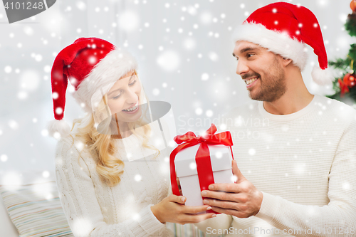Image of happy couple at home with christmas gift box