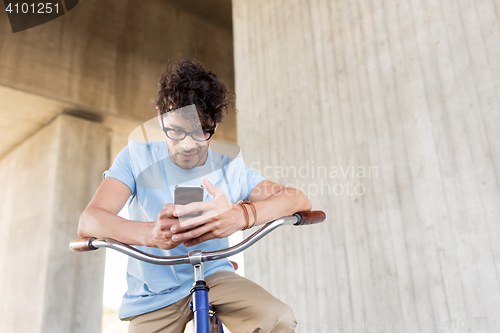 Image of man with smartphone and fixed gear bike on street