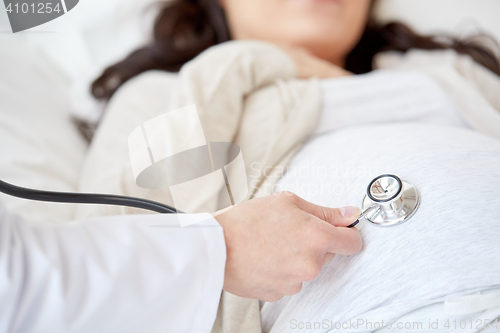 Image of doctor with stethoscope and pregnant woman
