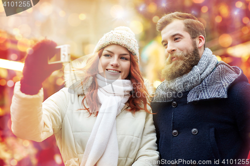 Image of couple taking selfie with smartphone in old town