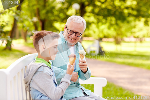 Image of old man and boy eating ice cream at summer park